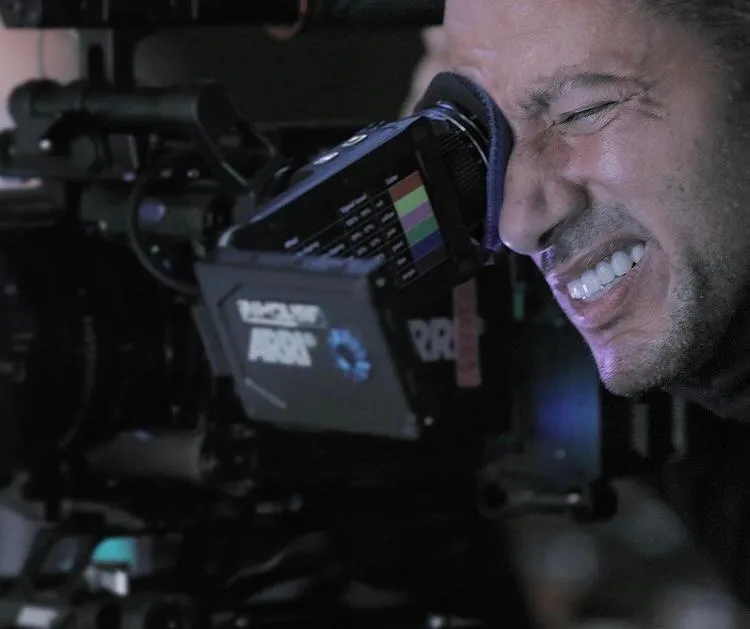 Waleed Nassif looking through the eyepiece of an ARRI cinema camera