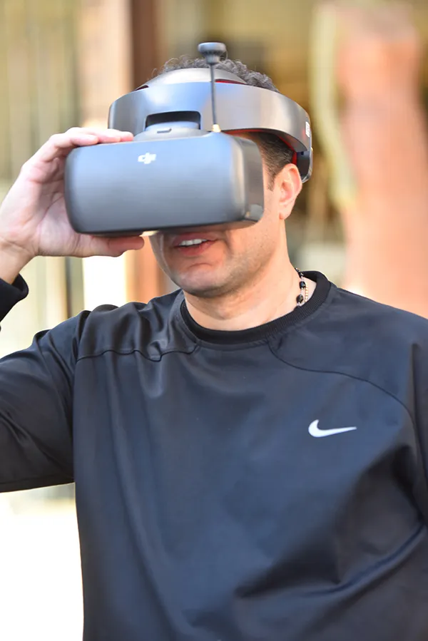 Waleed Nassif holding FPV drone goggles to his eyes