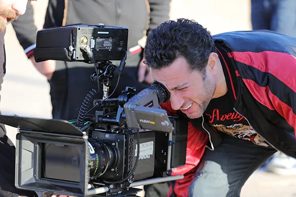 Waleed Nassif looking through an ARRI cinema camera on set