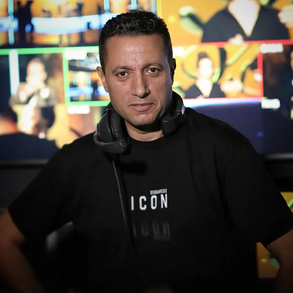 Waleed Nassif in a TV control room with monitors behind him